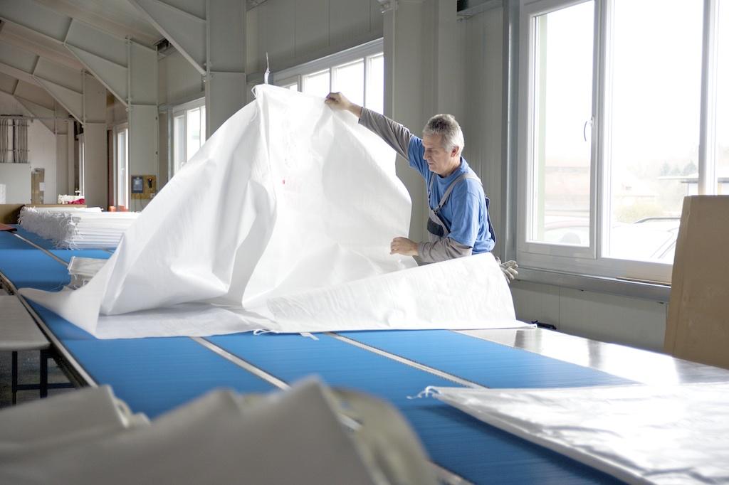 Een medewerker van G&H GmbH Rothschenk ontvouwt een afgewerkte opbergzak.