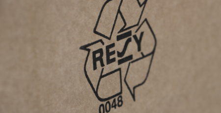 Een kartonnen doos met een recyclingbordje